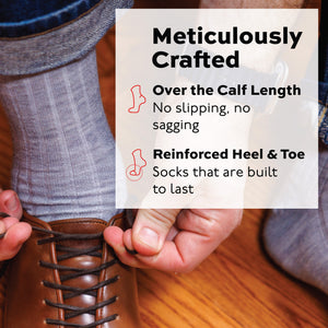 man tying his shoe wearing ight grey merino wool over the calf dress socks and jeans