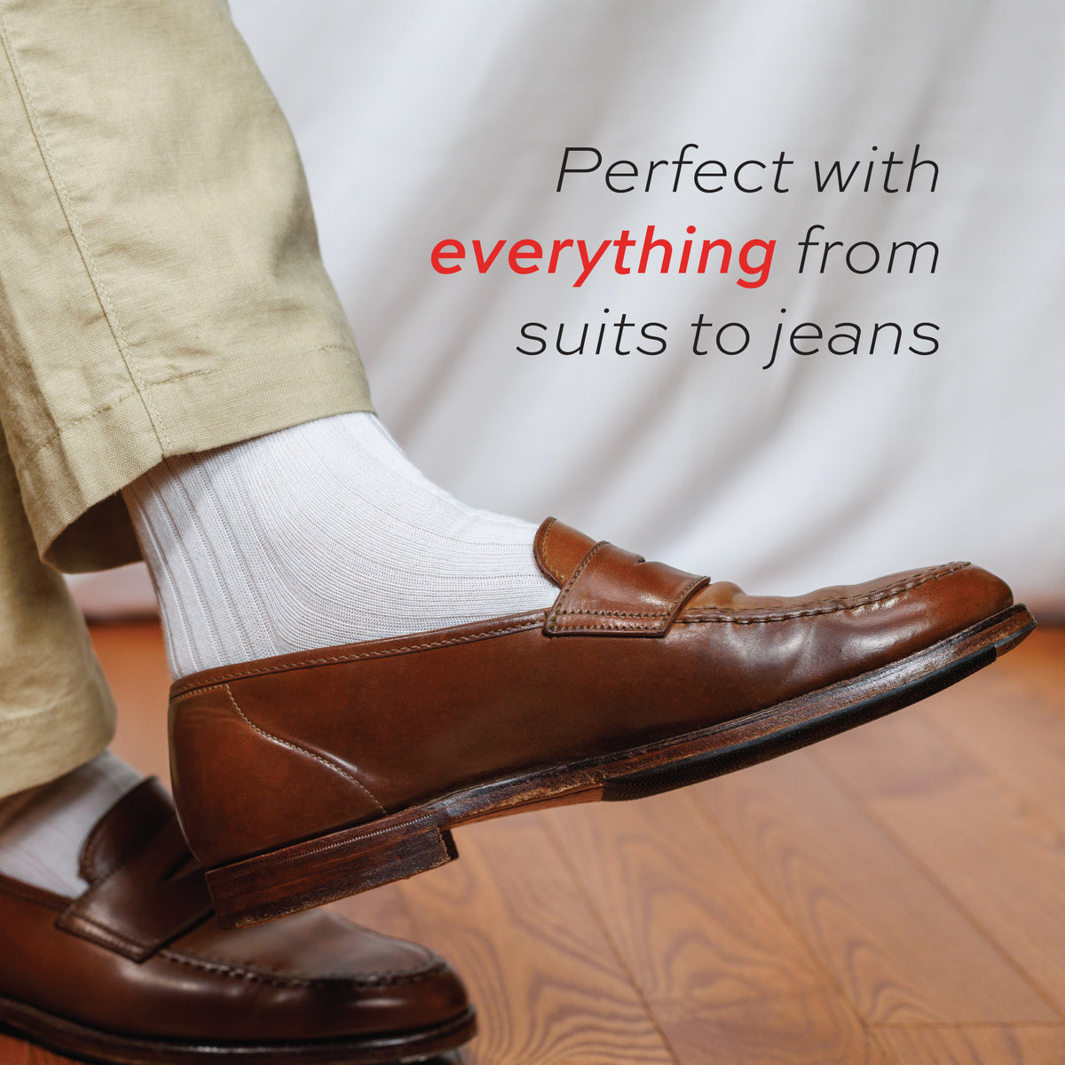 person wearing khakis and white ribbed merino wool dress socks with brown loafers