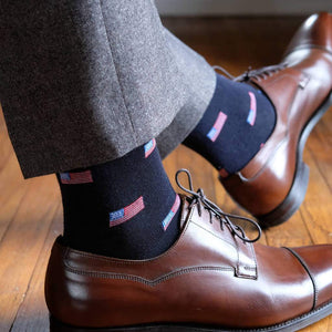 Man Wearing Grey Pants and Dark Brown Dress Shoes with Navy Blue Dress Socks Accented with Small American Flags