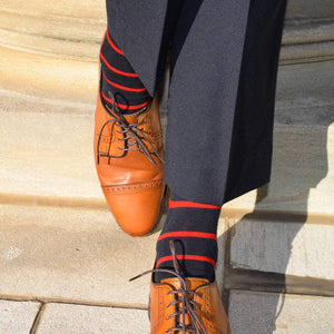 Man Wearing Navy Blue Dress Pants with Navy and Red Striped Dress Socks and Light Brown Dress Shoes