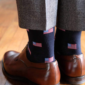 Man Wearing Grey Dress Pants and Brown Dress Shoes with Navy Dress Socks Decorated with American Flags