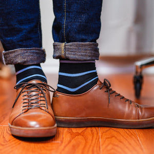 black and light blue striped dress socks paired with jeans and light brown leather sneakers