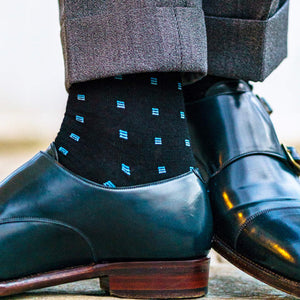 black merino wool dress socks decorated with bright blue patterns paired with blue monkstrap shoes and light grey trousers