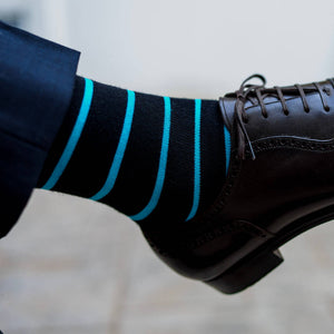 close up photo of black socks with bright blue stripes and navy pants
