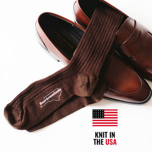 pair of brown merino wool dress socks sitting inside brown leather penny loafers