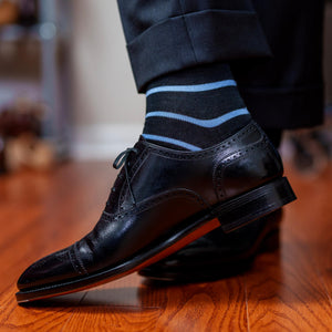 man wearing black and blue striped dress socks with black captoe oxfords and charcoal trousers