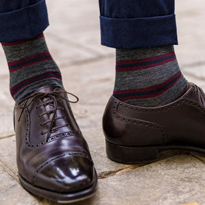 man standing wearing striped dress socks with navy trousers and dark brown dress shoes