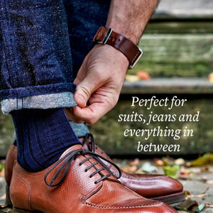 Man Adjusting Cuff of Jeans while Wearing Navy Blue Wool Dress Socks and Brown Dress Shoes