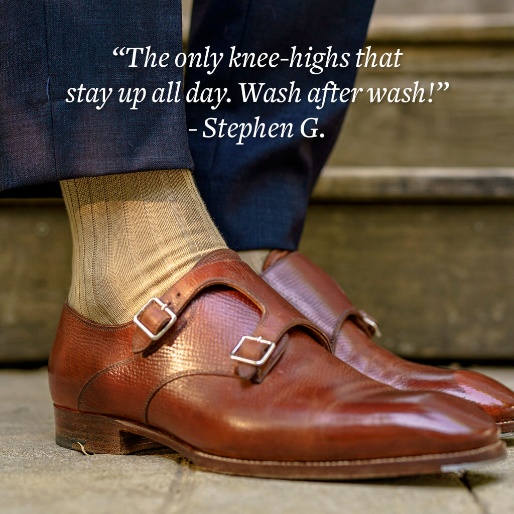 man standing wearing khaki dress socks with navy dress pants and brown leather monkstrap shoes