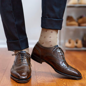 patterned tan dress socks with navy trousers and dark brown wingtip shoes