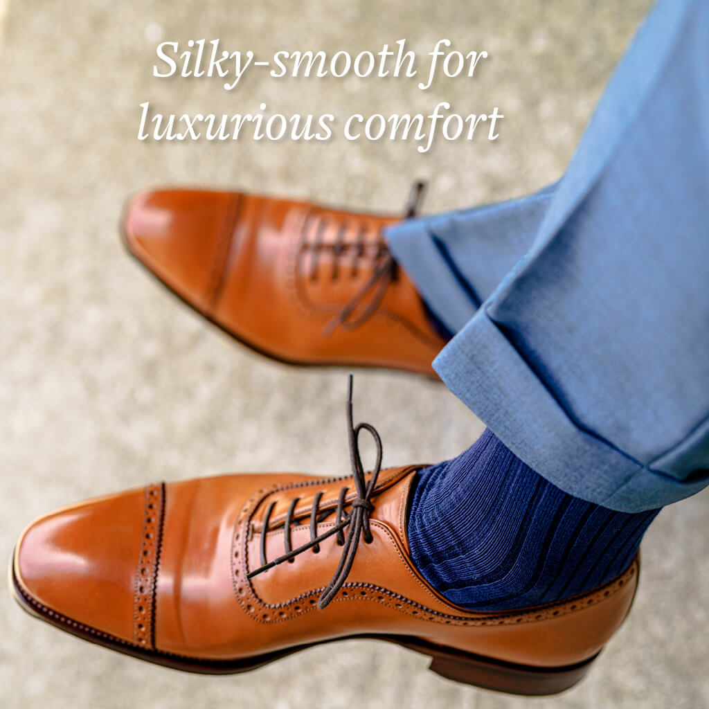 man crossing ankles wearing navy blue cotton dress socks