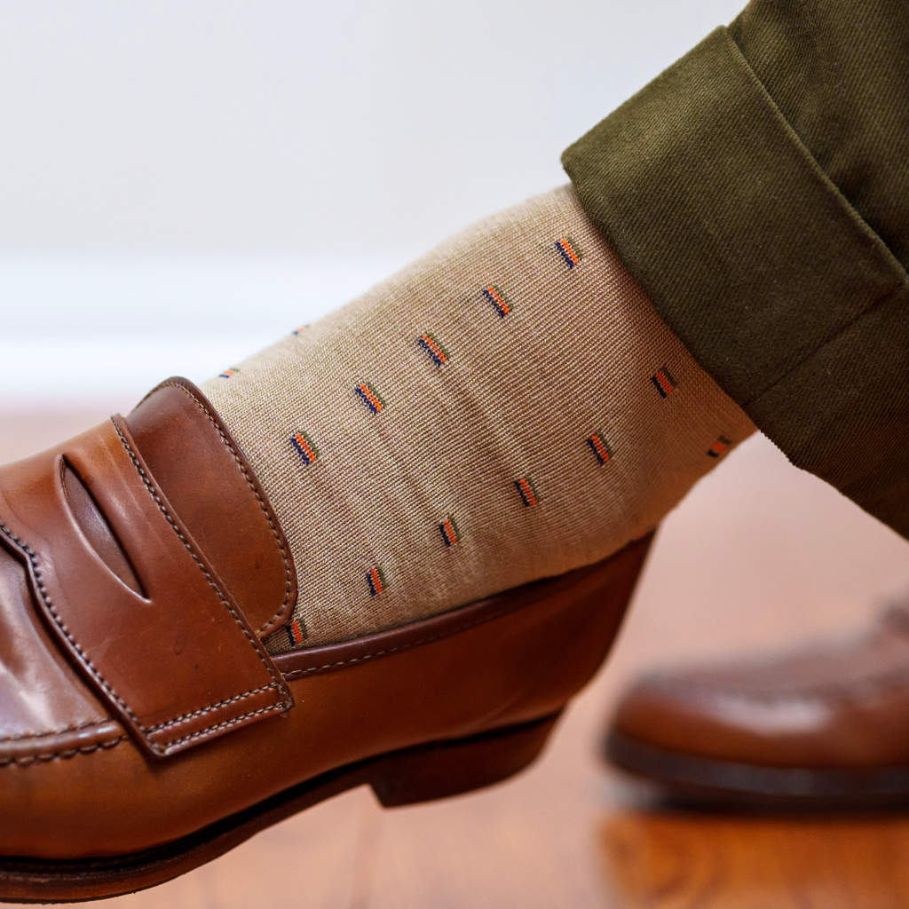 tan patterned dress socks with olive green trousers and brown penny loafers