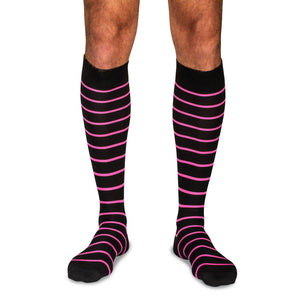 model wearing black over the calf dress socks with bright pink stripes