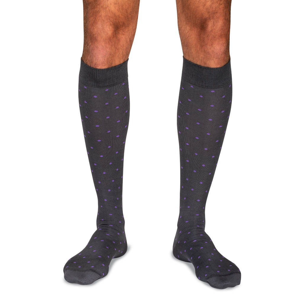 man wearing grey over the calf dress socks decorated with light purple polka dots