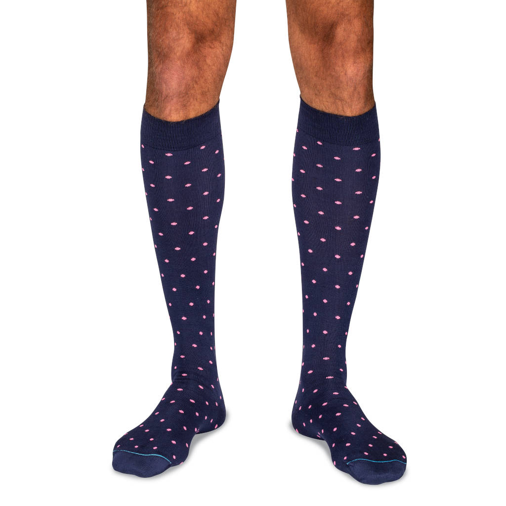 model wearing navy over the calf dress socks with pink polka dots