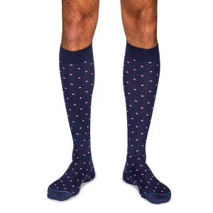 model wearing navy over the calf dress socks with pink polka dots