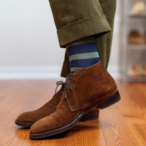 man standing wearing olive and navy dress socks with light brown chukka boots