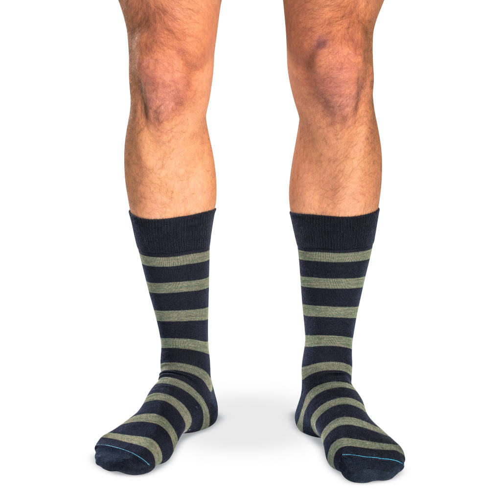 model wearing mid-calf length navy dress socks with horizontal olive green stripes