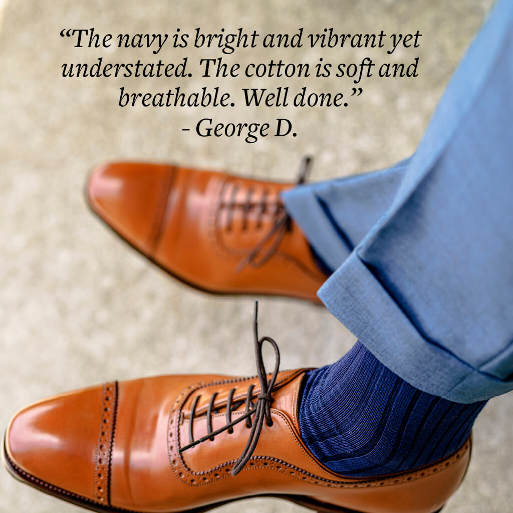 crossing legs with navy blue over the calf dress socks