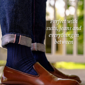 man pulling up jeans to show navy blue cotton dress socks