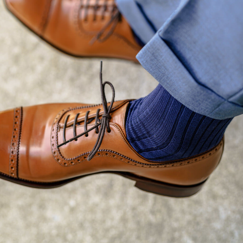 navy blue dress socks for men paired with light brown brogue dress shoes