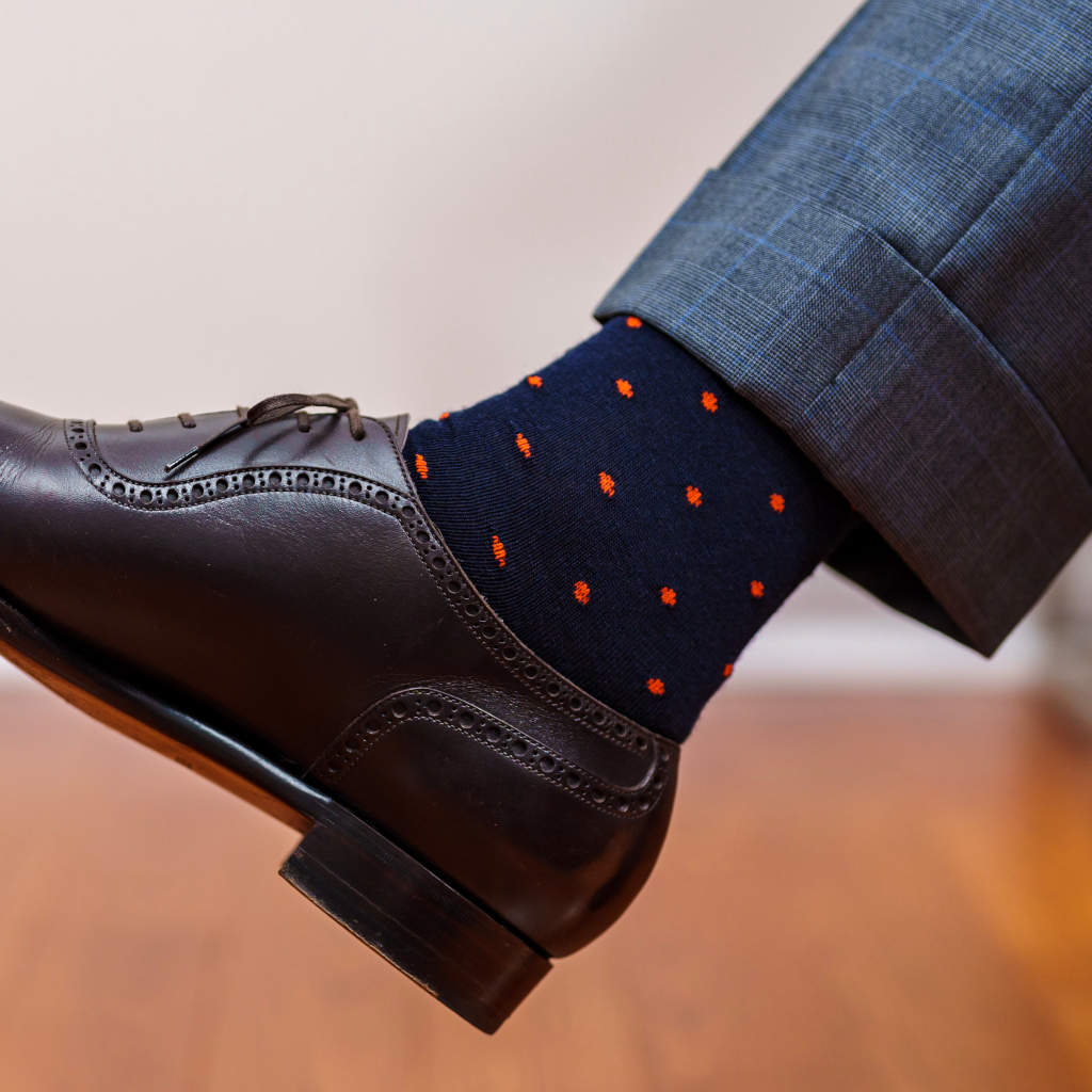 man wearing navy wool dress socks decorated with bright orange polka dots