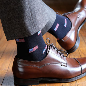 man wearing American flag dress socks and dark brown dress shoes with grey trousers