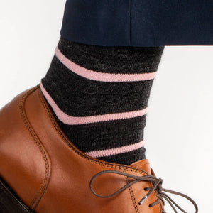 dark grey dress socks with light pink stripes paired with navy dress pants and light brown dress shoes