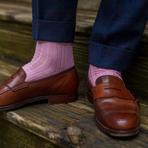 men's pink dress socks paired with brown loafers and navy plaid trousers