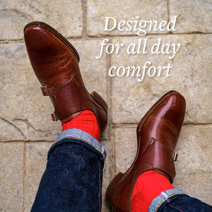 man wearing red dress socks with brown monkstrap shoes and dark wash denim